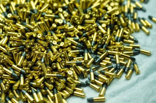 istock Heap of black and golden small-caliber bullets on table 1405436514