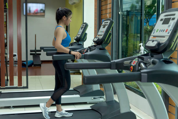 fitness kobieta ćwiczyć na sprzęcie treningowym,rozgrzać ciało na siłowni. - equipmet zdjęcia i obrazy z banku zdjęć