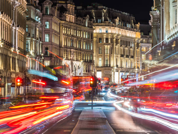 London Regent Street buses zooming past shops illuminated at night stock photo