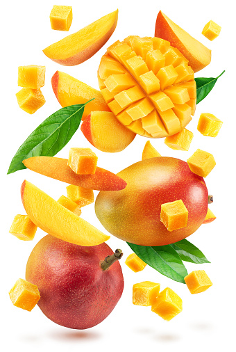 Collection of mango fruits, mango cubes and slices levitating in the air. File contains clipping path.