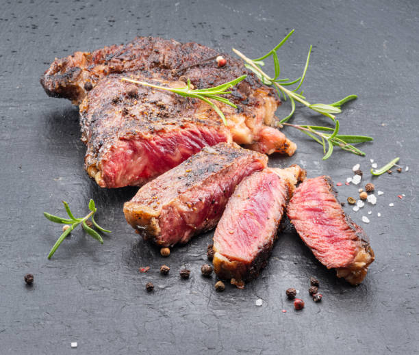 istock Grilled medium rare ribeye steak on gray stone plate. 1405442362