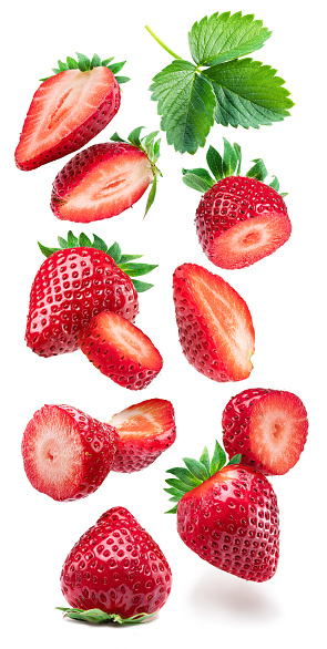 Strawberry and strawberry slices flying in the air slices on white background.