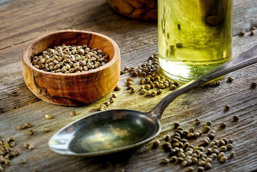 Hemp seeds and oil on wooden table