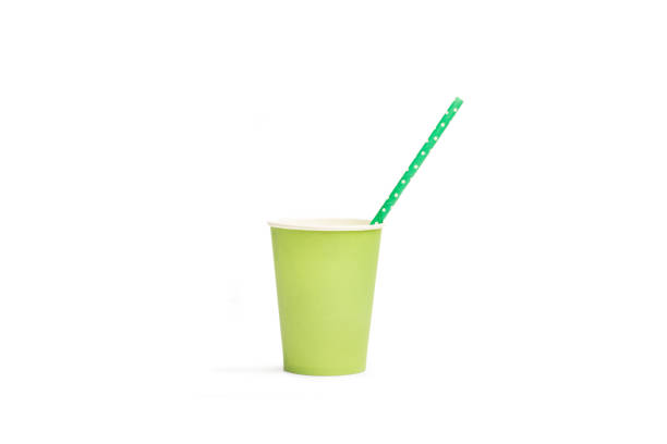 Drinking straw in a green paper drinking glass on a white background with copy space