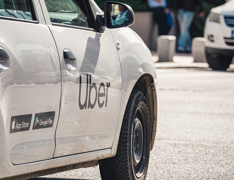 Bucharest, Romania -April 2022 : Car with the logo of the ride hailing company Uber in traffic.