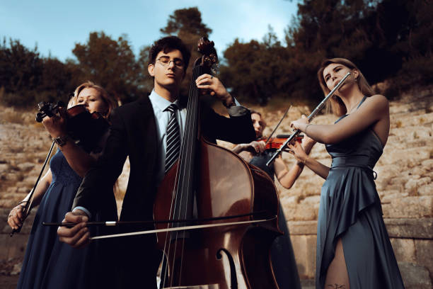 three musicians in blue dress and one musician in black suit in ancient theater. - bassoon imagens e fotografias de stock