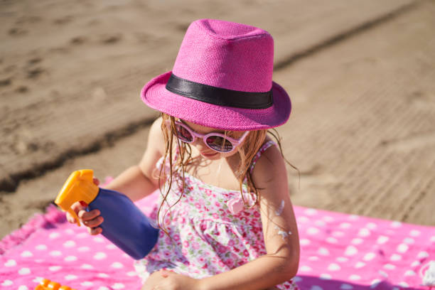 istock a girl applying sunscreen at the beach 1405449427