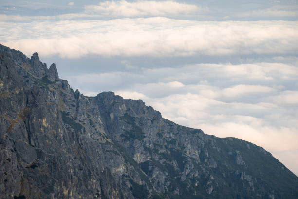 Massive mountain ridge towering above the clouds during sunset, Slovakia, Europe