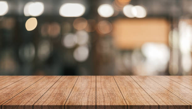 istock Empty wooden table top with lights bokeh on blur restaurant background. 1405451039