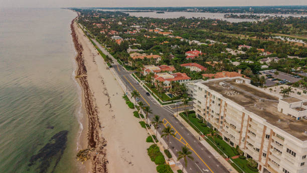 vista aérea de drone de beach-front real estate em palm beach, flórida durante um nascer do sol de verão dourado em 25 de junho de 2022 - villa summer rock sand - fotografias e filmes do acervo