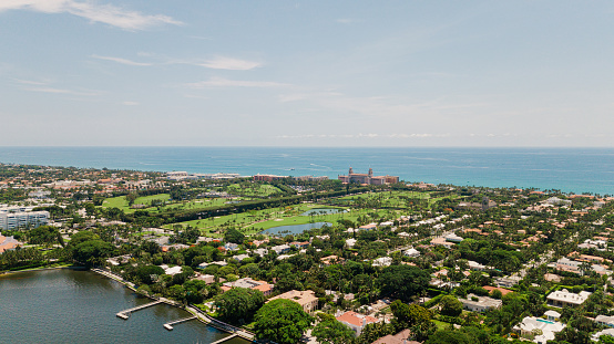 Aerial Drone View of the Waterfront Inlet in Downtown West Palm Beach, Florida & Palm Beach at Midday in June 2022