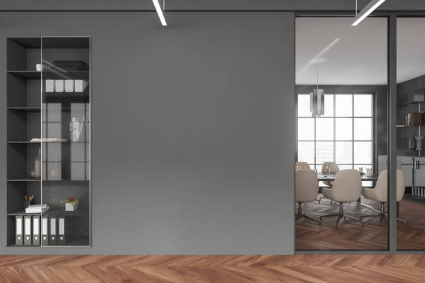 istock Grey office interior with armchair and table, window and shelf. Mockup wall 1405451654