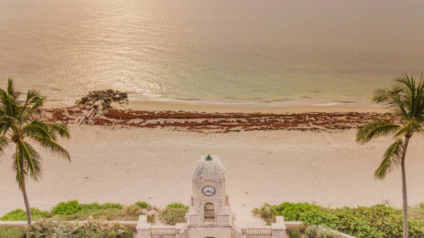 vista aérea de drone de ondas oceânicas de teal varrendo em terra durante um amanhecer dourado nublado em palm beach, flórida em 25 de junho de 2022 - below sea level - fotografias e filmes do acervo