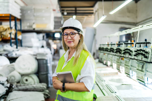 female engineer working with manufacturing equipment in a factory - machine operator imagens e fotografias de stock