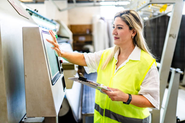 female engineer programming machine at factory - machine operator imagens e fotografias de stock