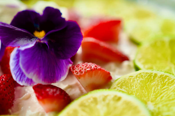 Top of a cheesecake with limes,strawberries, flowers