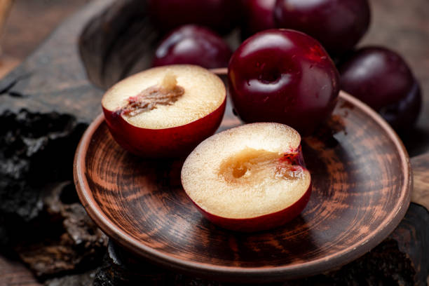istock Fresh sliced red plums on a dark wooden background. 1405459967