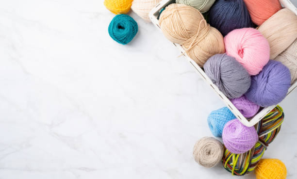 istock pastel colored yarn wool in a white basket on marble background 1405460631