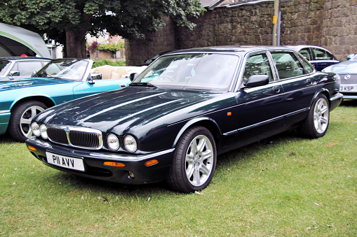 Oswestry in Shropshire in the UK in June 2022. A view of an Jaguar XJ series in a field