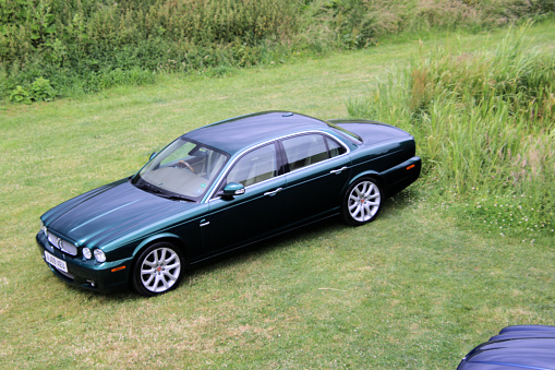 Oswestry in Shropshire in the UK in June 2022. A view of a Jaguar XJ series car on the grass