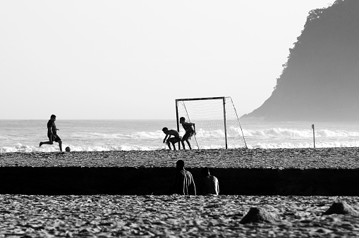 Group of boys playing soccer on the beach. Camburi Beach, São Sebastião - State of São Paulo, Brazil. June 23, 2022.