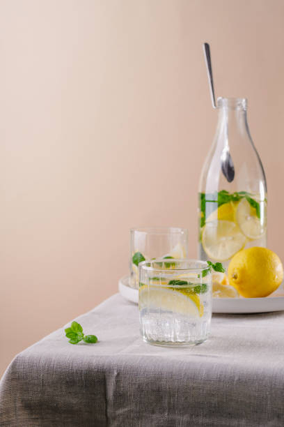 istock Refreshing summer drink with lemon and mint on the table. Lemonade in glasses and bottle 1405464576