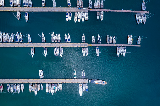 Aerial topdown view to a marina with moored luxury yachts and sailing boats in Greece