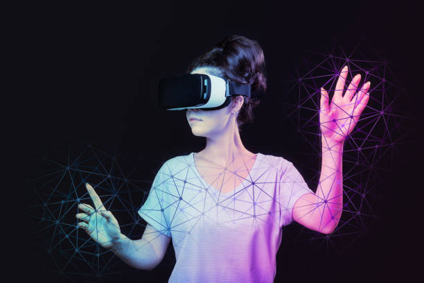 istock Metaverse and 3D simulation. A young woman in VR glasses creates neon abstract mesh. Dark background. The concept of virtual reality and futurism 1405467571