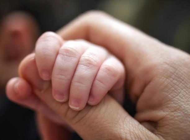 istock A baby's tiny hand holding on to its mother's 1405468185