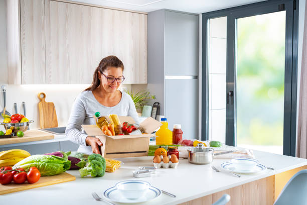 istock Woman in kitchen holding donation box 1405470608