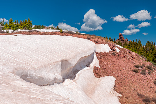 Winter snow, now discolored, melts on a hilltop on Shrine Ridge in Summit County Colorado.