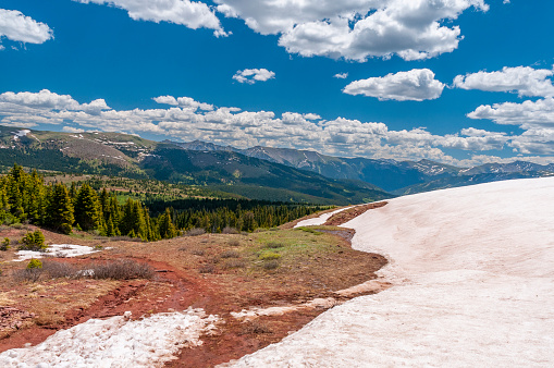 Winter snow, now discolored, melts on a hilltop on Shrine Ridge in Summit County Colorado.