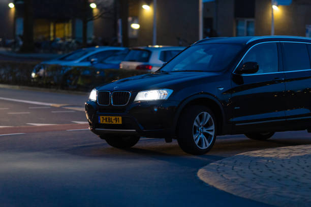 Wierden, Twente, Overijssel, Netherlands, april 11th 2022, cut out close-up of a Dutch black 2013 BMW X3 diesel SUV driving at a traffic circle in Wierden at night - the X3 is a luxury SUV made by German, Munich based automaker BMW since 2003