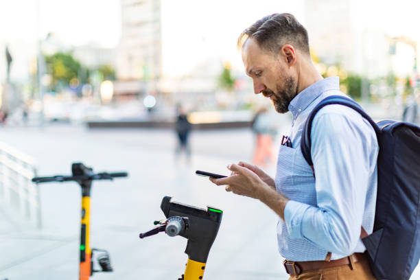 istock Young man renting electric scooter using smartphone 1405471886