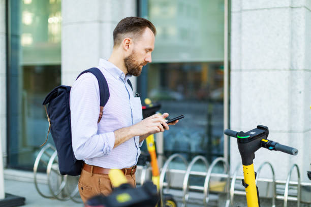 istock Young man renting electric scooter using smartphone 1405471944