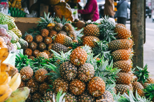 Selling pineapple fruits at local market in Mahebourg, Mauritius.