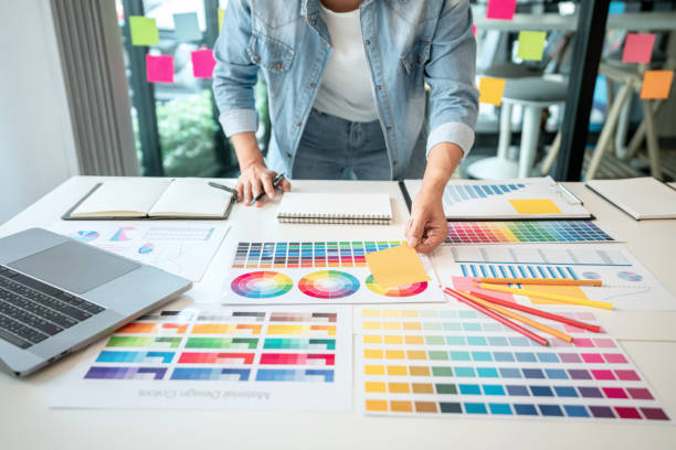 istock Young creative graphic designer working on color selection and drawing on graphics tablet at workplace, Color swatch samples chart for selection coloring in inspiration to create new collection 1405477772