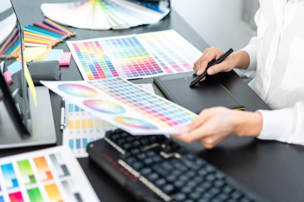 istock Young creative graphic designer working on color selection and drawing on graphics tablet at workplace, Color swatch samples chart for selection coloring in inspiration to create new collection 1405478202