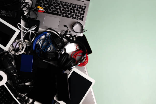 istock Old computers, digital tablets, mobile phones, many used electronic gadgets devices, broken household and appliances on green background. Planned obsolescence, electronic waste for recycling concept 1405480992