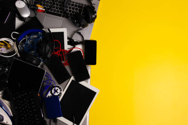 istock Old computers, digital tablets, mobile phones, many used electronic gadgets devices, broken household and appliances on yellow background. Planned obsolescence, electronic waste for recycling concept 1405481012