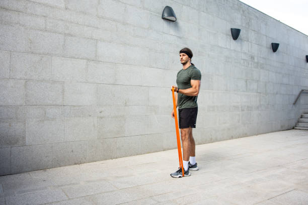 istock Young handsome man exercising with resistance bands 1405482284