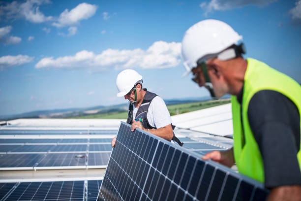 istock Teamwork is dreamwork. Team of electricins installing solar panels on warehouse roooftop. 1405482346