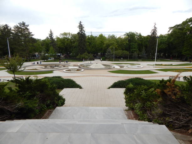 istock Beautiful park with fountains surrounded by greenery 1405489296