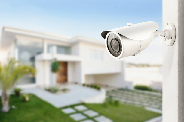 Three quarter view of varifocal surveillance camera, with a house on background Three quarter view of varifocal surveillance camera, with a house on background big brother orwellian concept stock pictures, royalty-free photos & images