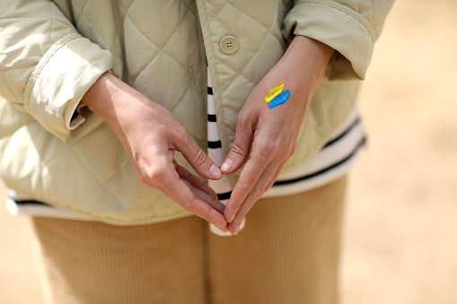Stop War. Peace in Ukraine. woman with picture of flag of ukraine on hand. Antiwar support concept. High quality photo.