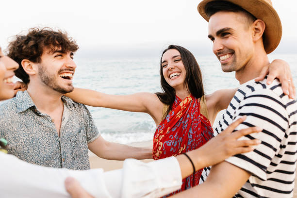 istock Group of happy young friends laughing together while having fun on the beach 1405493078