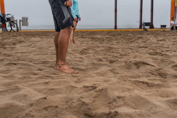 istock Legs of people standing on the sand of a beach while training 1405496439