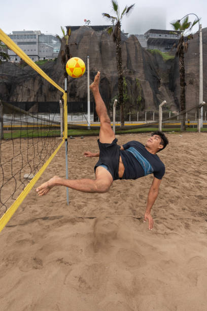 istock Man jumping to kick a ball during a footvolley training session 1405496471