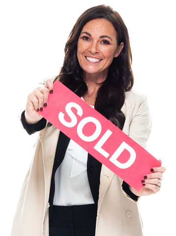 Front view of aged 40-44 years old who is beautiful with long hair caucasian female manager standing in front of white background wearing businesswear who is smiling and holding sign