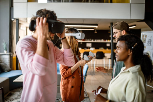 istock Group of university students in the office using VR simulator headsets, having fun 1405498512